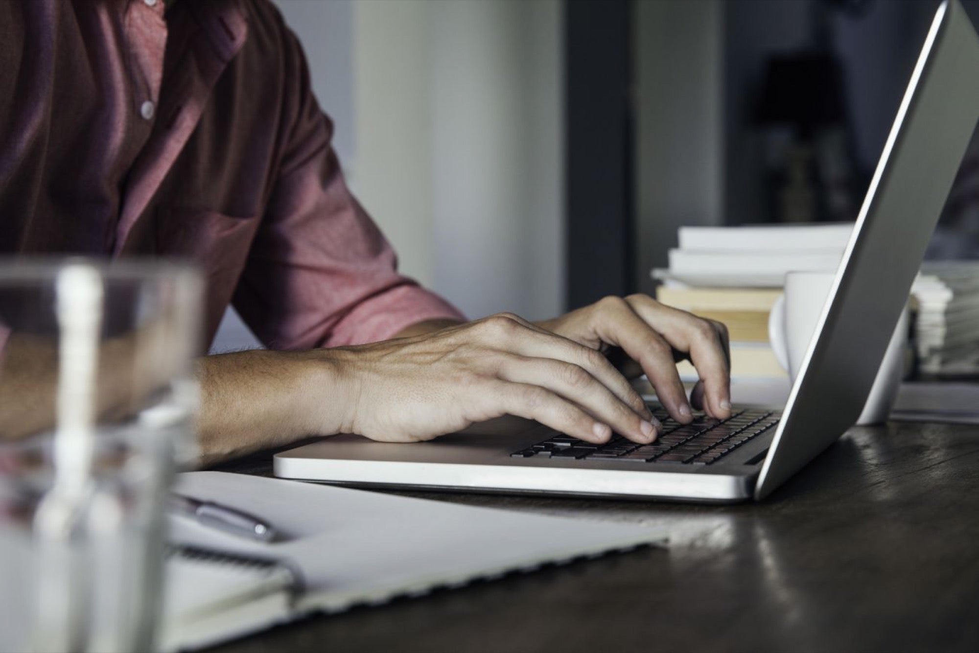 A man sitting at a table using a laptop computer