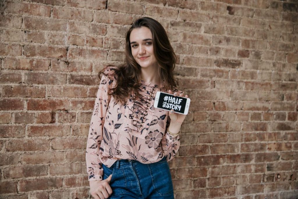 Larissa May standing in front of a brick wall